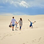 Familie am Strand im Sand während Familienurlaub in Dänemark