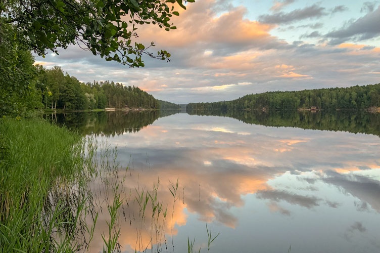 Ein See in Finnland auf dem sich die Wolken spiegeln.