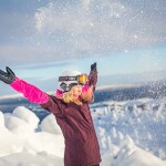 Kind im Urlaub im Schnee mit Skiausrüstung
