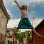 Glückliches Kind, das hochspringt im Urlaub in Finnland mit der Familie