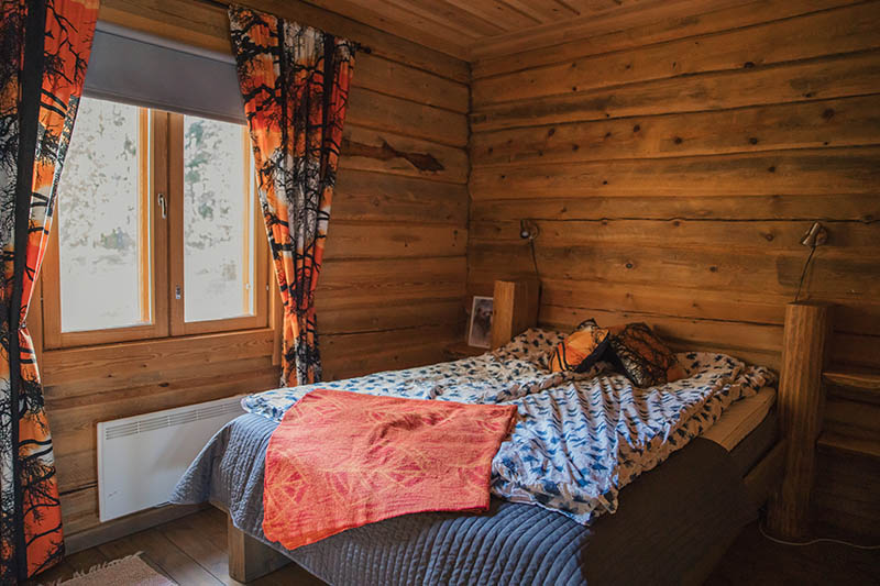 Schlafzimmer in einem typisch finnischen Ferienhaus mit urigen Holzwänden.