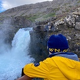 In Island am Wasserfall eine Familie mit Kindern – auf Abenteuer im Familienurlaub in Island.