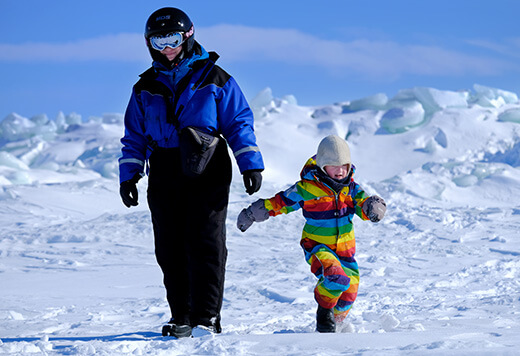 Ein Mann und ein Kind wandern durch den Schnee.