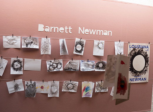 An einer Wand hängen nachgemalte Bilder von Barnett Newman.