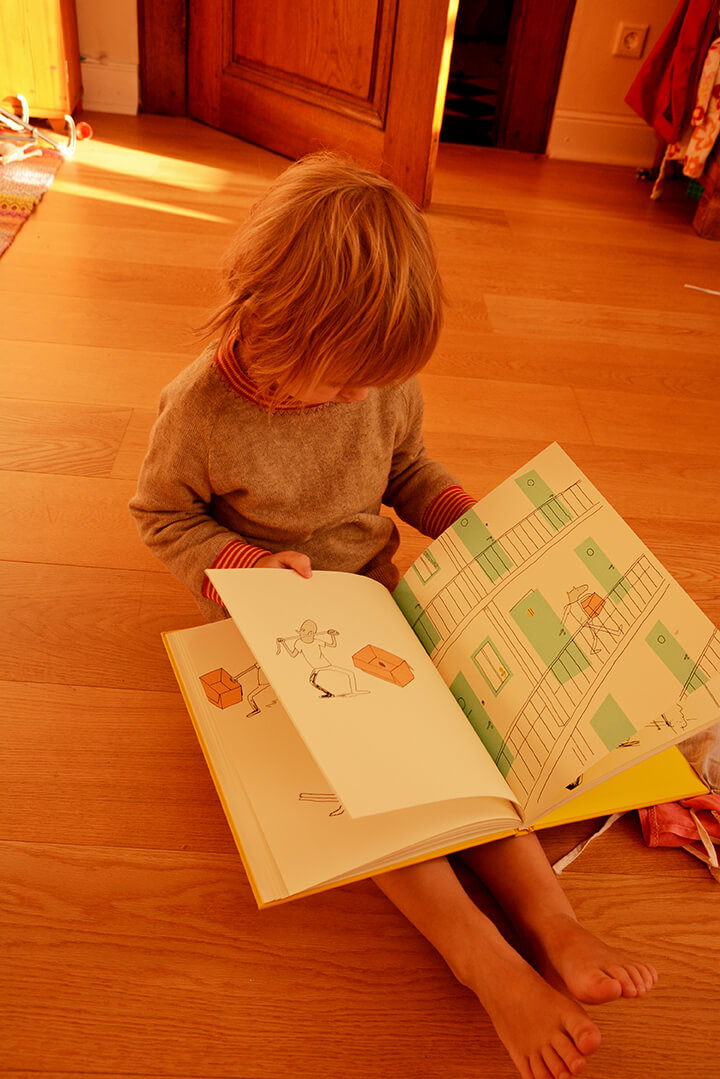 Ein Kind blättert durch das Kinderbuch das Loch.