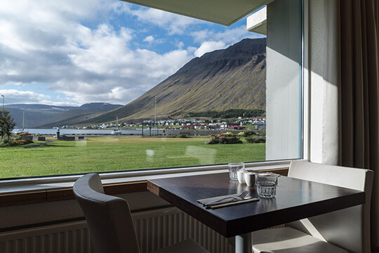 Ein Tisch mit zwei Stühlen an einem Fenster mit wunderbarem Blick in die Landschaft.