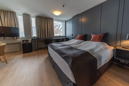 Blick auf ein Doppelbett in einem Hotelzimmer.