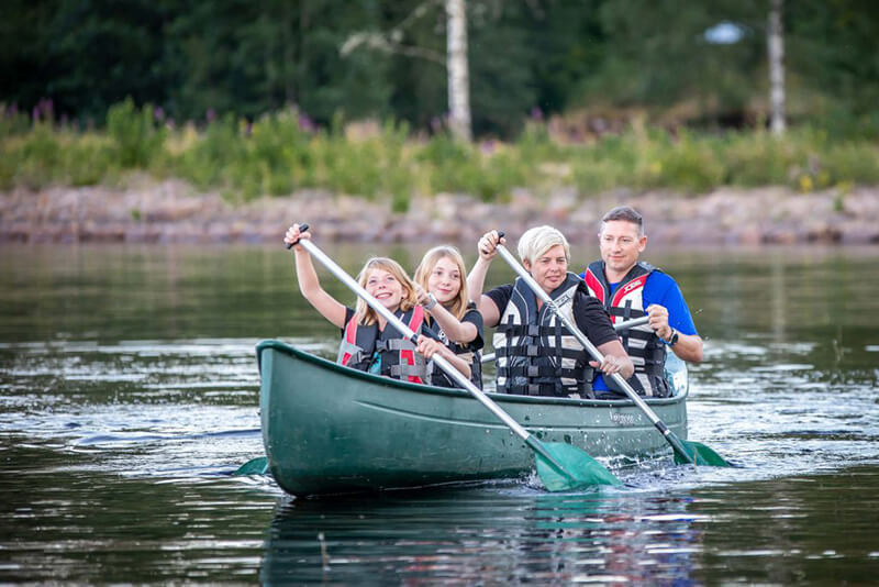 Eine Familie sitzt im Kanu und paddelt.