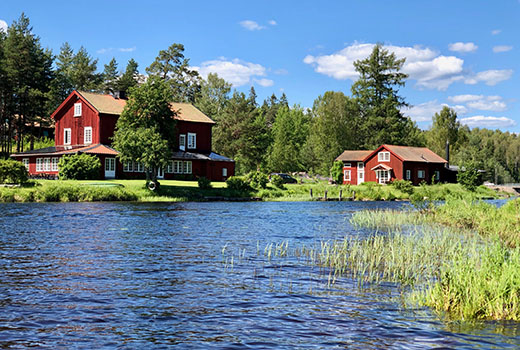 Rote Häuser an einem See.