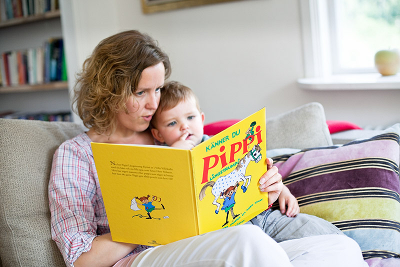 Mutter mit Kind auf der Couch mit einem Pippi Langstrumpf Buch