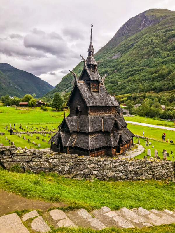 Große Stabkirche in einem grünen Tal mit Bergen im Hintergrund