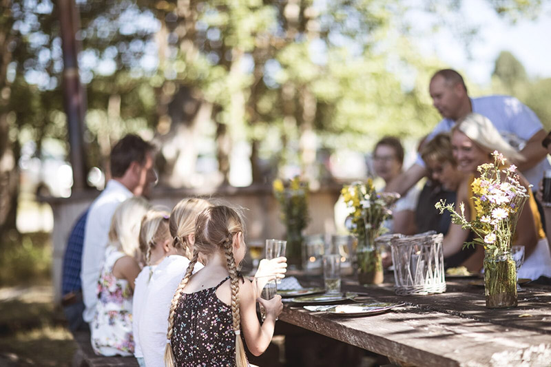 Eine Familie sitzt gemeinsam an einem Tisch im Freien.