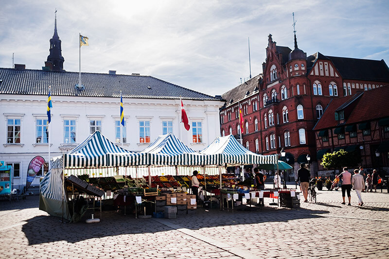 Der Marktplatz von Ystad. Im Vordergrund sind Gemüsestände zu sehen.