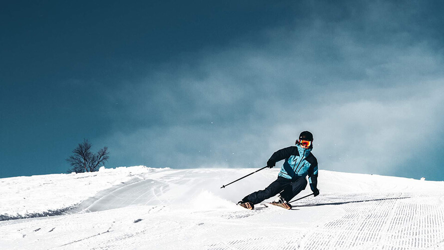 Ein Skifahrer bei der Abfahrt in einer Kurve. 