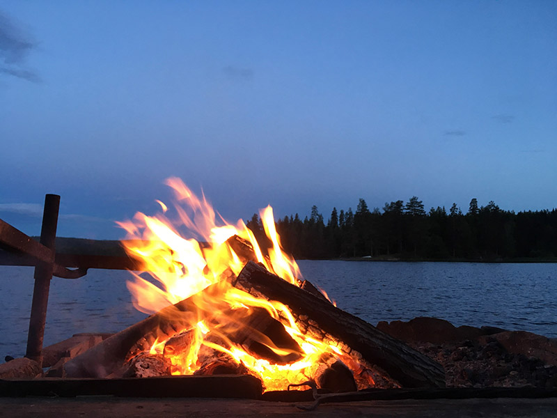 Lagerfeuer am Seeufer bei Nacht 