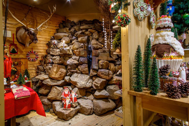 Ein weihnachtlich geschmücktes Geschäft bei dem in einer Ecke Steine und Figuren der yule lads zu sehen sind. 