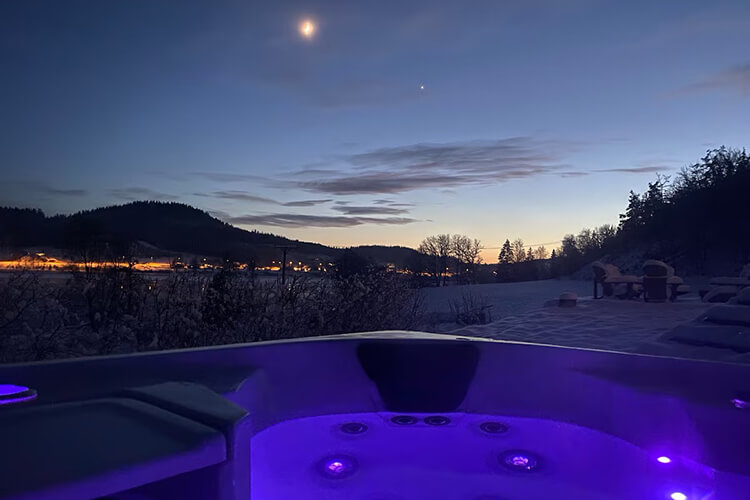 Ein Jacuzzi vor einer nächtlichen Landschaft.