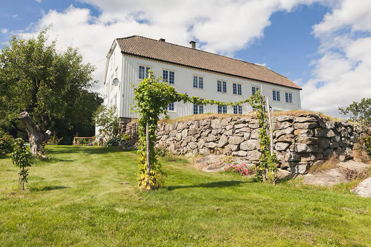 Ein weißes Holzhaus mit großem Garten.