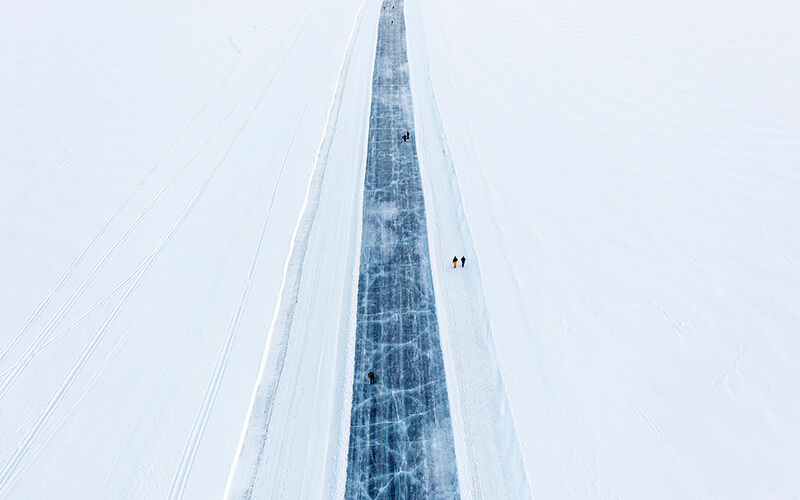 Eine freigeräumte Straße auf Eis mit Schnee.
