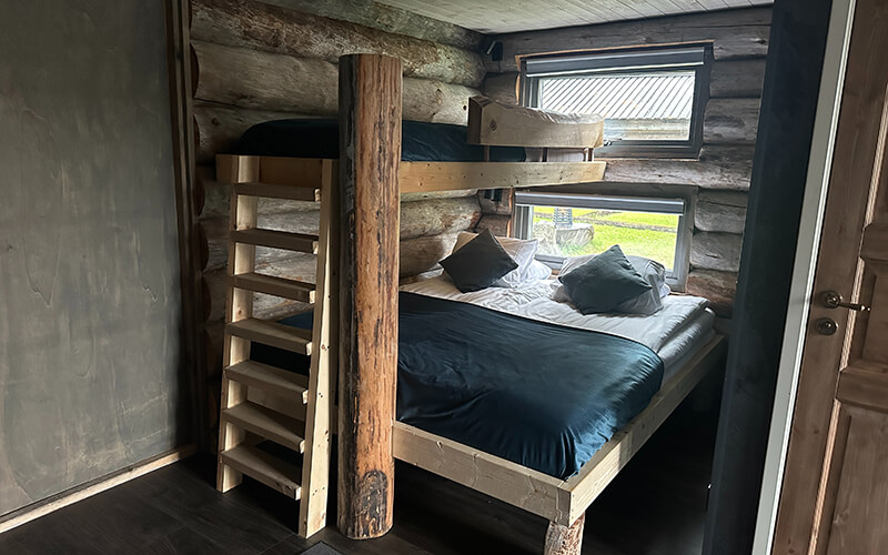 Ein Stockbett aus Holz in einer Blockhütte.