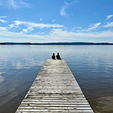 Zwei Kinder auf einem Steg am See.