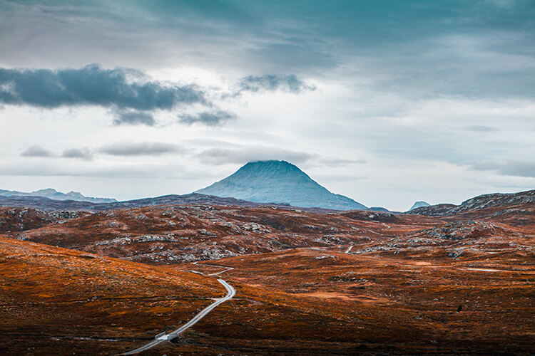 Ein Berg im Hintergrund, im Vordergrund sieht man eine herbstliche Landschaft.