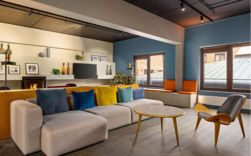 Eine bunte Hotellobby mit einem großen Sofa und Stühlen.